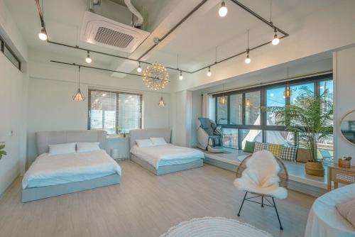 a bedroom with two beds and a couch and a chair at Mazihouse in Mukho-dong