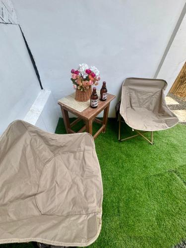 a tent with a table and a chair and flowers at Nay Carmen Pension House Port Barton in Itaytay