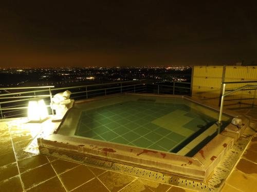 a hot tub on top of a building at night at Tsukubasan Hotel Aokiya in Tsukuba