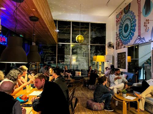 a group of people sitting at tables in a restaurant at STAY Rhodes HoStel & Bar in Rhodes Town