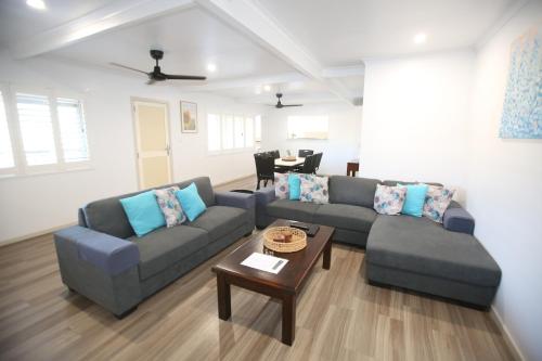 a living room with two couches and a table at Whitsunday Sands Resort in Bowen