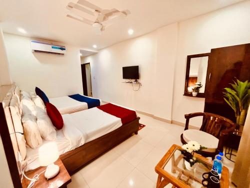 a bedroom with a bed and a table and a tv at Sitara Economy The Pacific, Haridwar in Haridwār