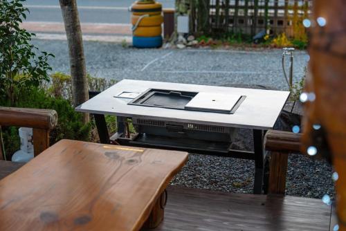 a table with a laptop on it next to a bench at Suncheon Slow Pension in Suncheon