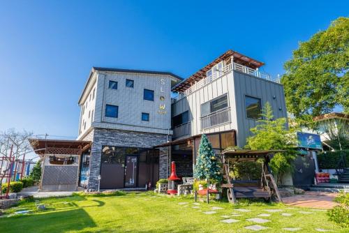 a house with a christmas tree in the yard at Suncheon Slow Pension in Suncheon