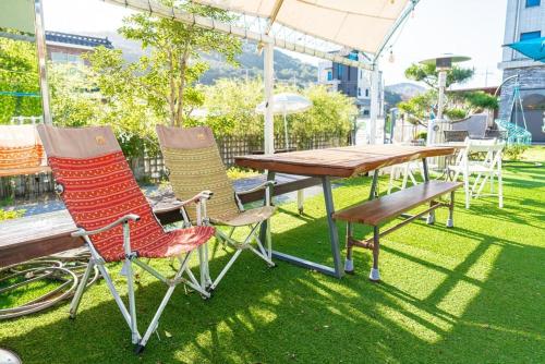 a table and two chairs and a table and a bench at Suncheon Slow Pension in Suncheon