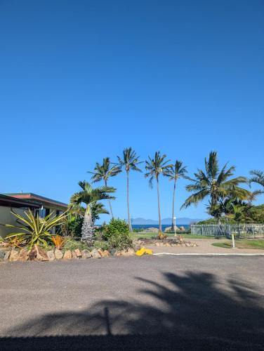 a street with palm trees on the side of a road at Whitsunday Sands Resort in Bowen