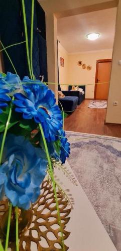 a vase with blue flowers sitting on a table at Genex-M in Bugojno