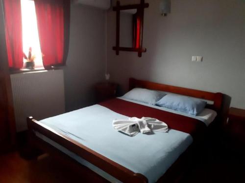 a bedroom with a bed with a ribbon on it at Genex-M in Bugojno