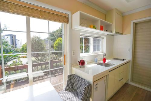 a kitchen with a sink and a large window at Jubilee Chalet in Seogwipo