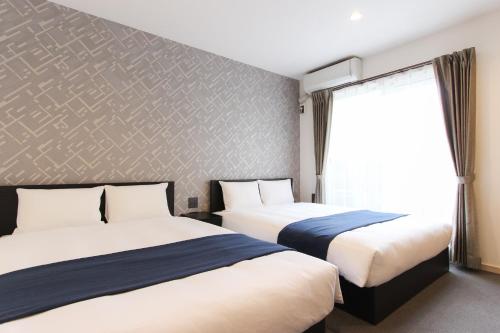 une chambre d'hôtel avec deux lits et une fenêtre dans l'établissement Hotel SALIFORT HAKATA, à Fukuoka