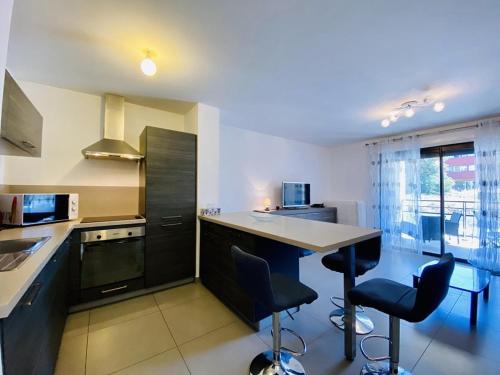 une cuisine avec un comptoir et deux tabourets de bar dans l'établissement PORTO PIANO 2 pièces au coeur de la ville, à Propriano
