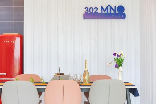 a table with pink chairs and a bottle of wine at Gangneung Stay 302 in Hwapyeong-dong