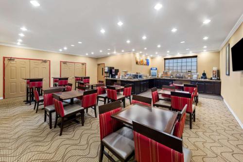 a restaurant with tables and chairs and a counter at Comfort Suites Roanoke - Fort Worth North in Roanoke