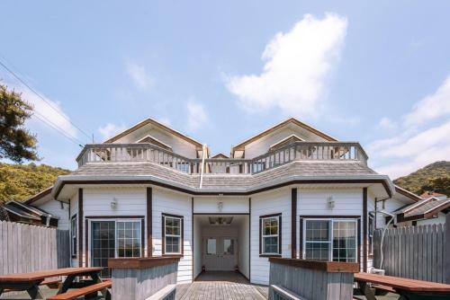 a white house with a porch and a fence at Ganghwa Gom Pension in Changhwa-ri