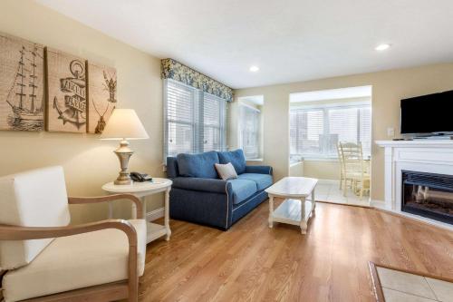 a living room with a blue couch and a fireplace at Bluegreen Vacations The Breakers Resort, an Ascend Collection Resort in Dennis Port