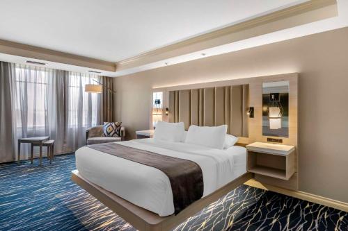 a hotel room with a large bed and a chair at Wyvern Hotel, an Ascend Collection Hotel in Punta Gorda