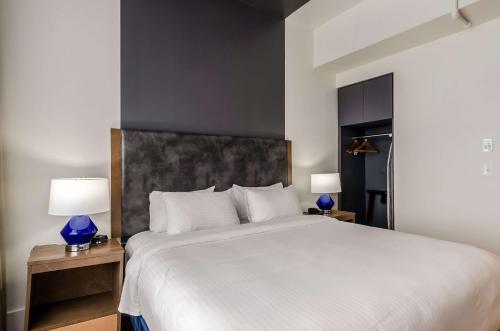 a bedroom with a large white bed with blue lamps at New Bedford Harbor Hotel, an Ascend Collection Hotel in New Bedford