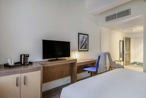 a hotel room with a desk with a tv and a bed at New Bedford Harbor Hotel, an Ascend Collection Hotel in New Bedford