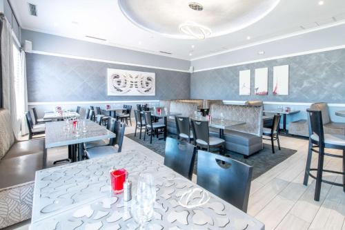a dining room with tables and chairs in a restaurant at Wyvern Hotel, an Ascend Collection Hotel in Punta Gorda