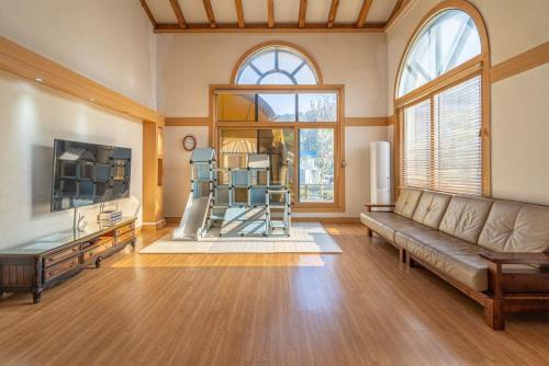 a living room with a couch and a large window at Daebudo Siesta Pension in Ansan