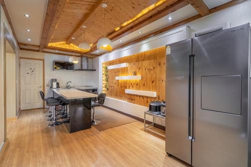 a kitchen with a refrigerator and a table in a room at Daebudo Siesta Pension in Ansan