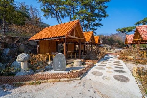 a small building with an orange roof and a grave at Saint in Udumji Pool Villa in Sanjeong-ri