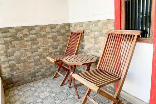 two wooden chairs sitting next to a window at Urbanview Hotel Permata Syariah Garut in Paledang
