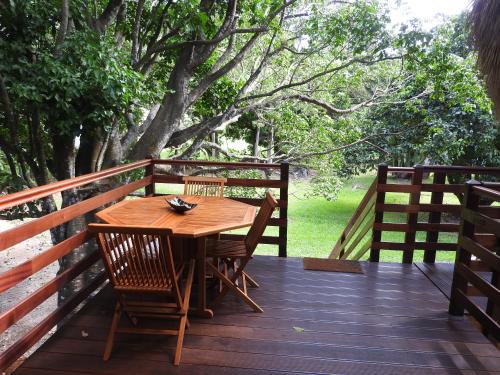 a wooden table and chairs on a wooden deck at Insolite Ara Wakan / Ma cabane in Pointe-Noire