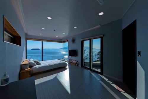 a bedroom with a bed and a view of the ocean at Sacheon Bileong Pool Villa Pension in Sacheon
