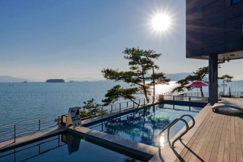 a swimming pool with a view of the water at Sacheon Bileong Pool Villa Pension in Sacheon