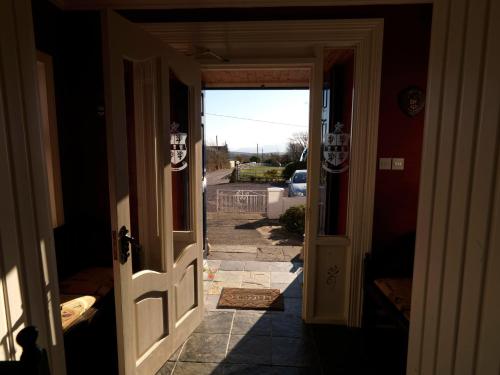 an open door to a hallway with a driveway at Murphys Farmhouse B&B in Castlemaine