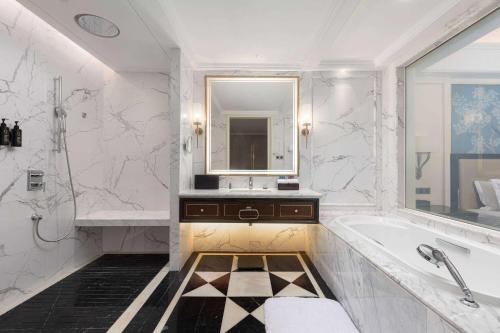 a bathroom with a tub and a sink and a mirror at Wyndham Taian West in Tai'an