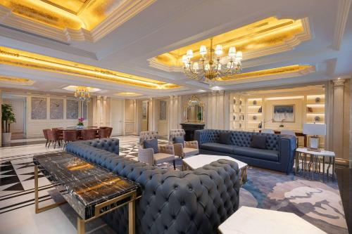 a living room with blue couches and a dining room at Wyndham Taian West in Tai'an