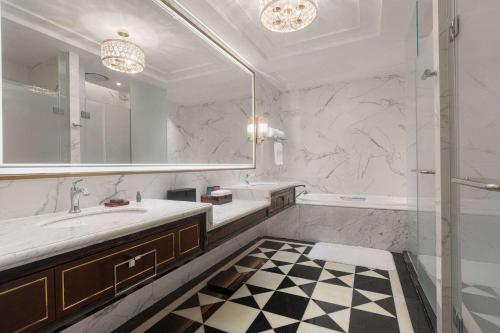 a bathroom with a sink and a mirror and a tub at Wyndham Taian West in Tai'an