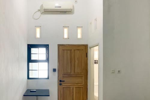 a hallway with a door and a air conditioner at Urbanview Hotel Permata Syariah Garut in Paledang