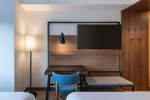 a dining room with a table and a tv at Tru By Hilton Cali Sur in Cali