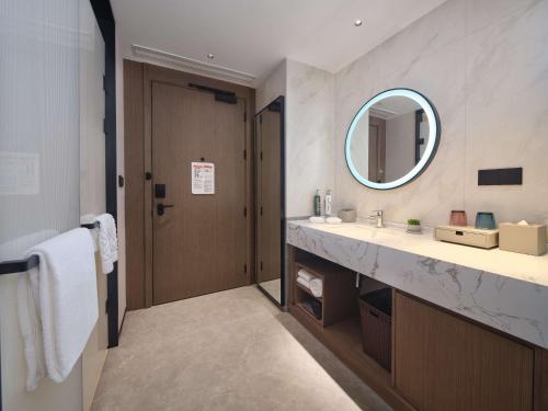 a bathroom with a sink and a mirror at Hilton Garden Inn Ji'Nan High-Tech Zone in Jinan