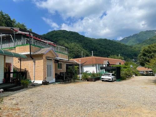 a house with a car parked in a driveway at Hill House Pension in Inje