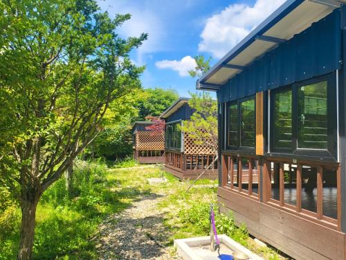a house with a blue roof and a yard at Muju camping Caravan in Samgong