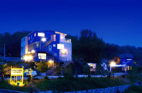 un edificio azul y blanco por la noche con luces en Amy Bada, en Incheon