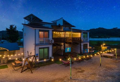 ein Haus mit Lichtern davor in der Nacht in der Unterkunft Family Couple Pension Harupia in Taean