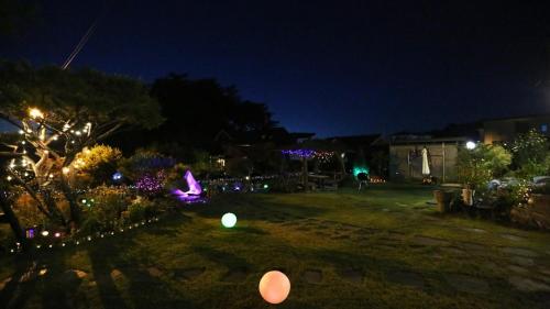 a yard lit up at night with christmas lights at Cheongju Chojeong Stay in Cheongju