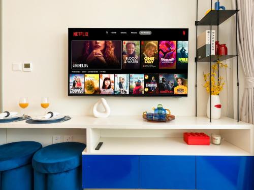 a room with a tv on a wall with blue stools at Modern High-Floor Apartment with Burj Khalifa View by Dejaview Stays in Dubai