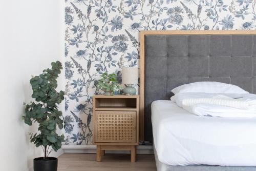 a bedroom with a bed and a plant at Delfin Szív Háza - Szauna és Jakuzzi in Tengőd