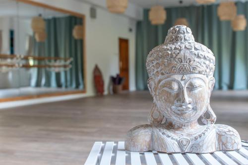 a statue of a head sitting on a table at Delfin Szív Háza - Szauna és Jakuzzi in Tengőd