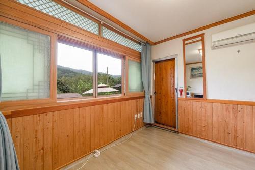 an empty room with a large window and wooden walls at Boseong Jihye Hanok Guesthouse in Boseong