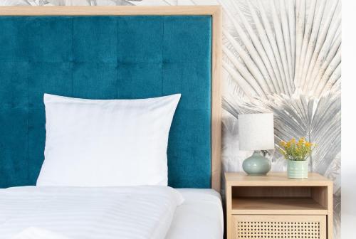 a bedroom with a blue headboard and a white bed at Delfin Szív Háza - Szauna és Jakuzzi in Tengőd