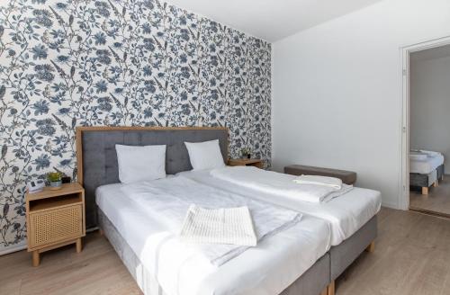 a bedroom with a bed with a blue and white wallpaper at Delfin Szív Háza - Szauna és Jakuzzi in Tengőd