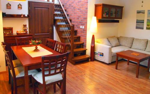 a living room with a couch and a table and a dining room at Hrabovo Lake View Apartment in Ružomberok