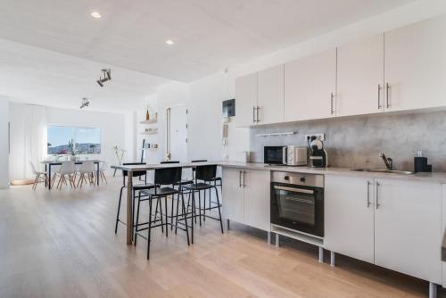 une cuisine avec des armoires blanches et une table et des chaises dans l'établissement El Mirador , Playa ,Vistas puerto,Wifi, à Las Palmas de Gran Canaria